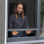 Nainen avaa sisätiloissa ikkunan molemmin käsin, jossa on Hyttysverkko ikkunaan - rullaverkko.