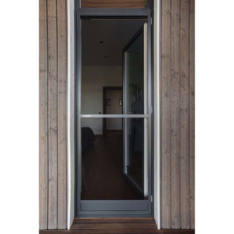 En Myggnät dörr - öppningsbar med en mörk metallram är placerad i en trävägg och visar det inre rummet genom sitt glas.