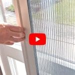 A hand opens an Insect screen door - foldable next to a window, with a YouTube play button overlay at the center.